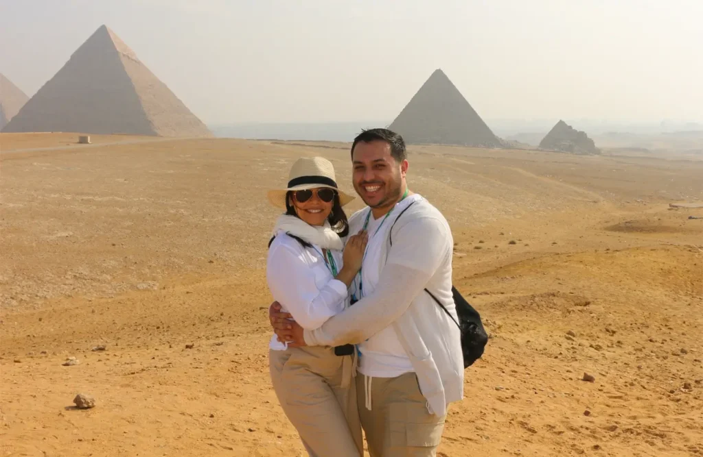 A couple dressed in white in front of the Giza Pyramids