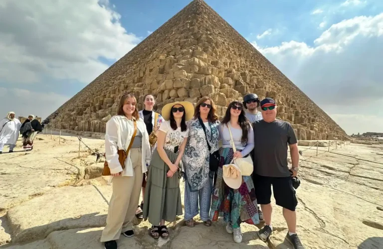 A group of visitors in front of the Great Pyramid of Giza